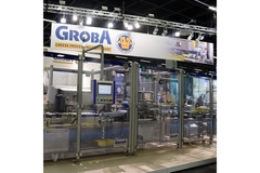 Groba cheese processing equipment displayed at a trade show with automated machinery and control panel.